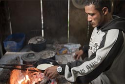 Preparing pancakes in camp on open fire.