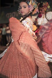 Young carnival girl in red dress, performes and poses as the old do. Las Tablas.