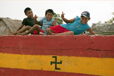 Guna children in Playa Chico. Swastika flag adopted since 1925 rebellion. Guna Yala, Panama.