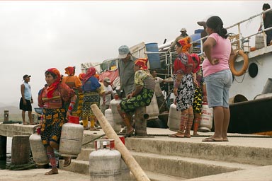 Guna women carry away gas-bottles, from commercial ship, docked on Ustupu, Guna Yala island.