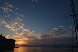 Sunset over Rovinj and sailboat.