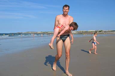 Lionnel carries Violette on the beach
