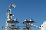 Detail of fishing vessels, lighting. Two birds, blue sky.