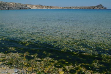 Green boulders, blue water, Lindos bay.