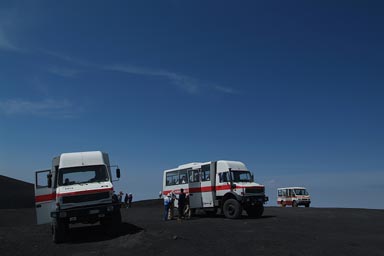 Mount Etna, top of 2,900m, Mercedez Unimogs, tourists, blue sky.