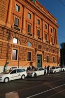 Ocre building shines and white taxis.