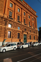 Ocre building shines and white taxis.