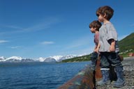 Olderdalen, Norway, Lyngen in back, twins in gumboots on pier.