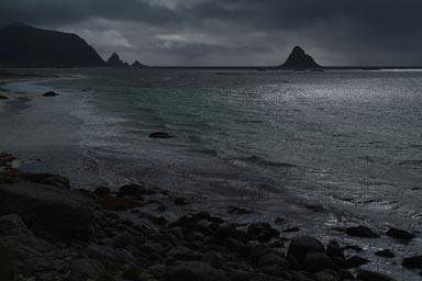 Against the sun, dark clouds, coast and islands, Norway.