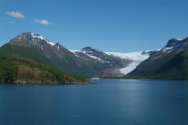 A glacier extends to banks of a fjord, Norway.
