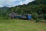 Blue train on bridge. Carriages.