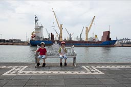 Boys sitting on bench on Vera Cruz dock, Gulf of Mexico.