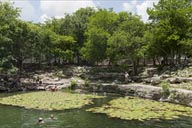 Maya site of Dzibilchaltun, tourists taking bath in Cenote, pool, fresh water reserve. Yucatan.