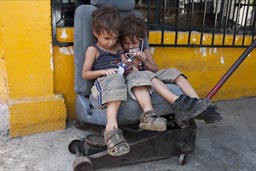 Boys wait patiently, while car is being fixed.