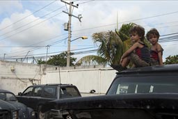 Boys get bored after a while, climb top of van, in garage in Cancun.