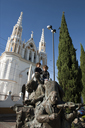 Boys on top of mariachi sculpture in front of white San Jore church in Comitan, Chiapas. Blue sky.