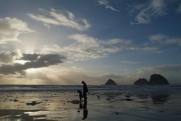 Three Arches Rocks, father and son on beach.