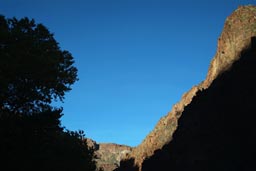 Last rays of sunlight touch Grand Canyon cliffs.