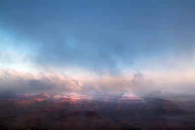 Snow clouds turn blue sky, Grand Canyon.