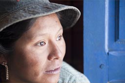 Indigenous Aymara woman and hat, blue door, Bolivia, Coipasa.