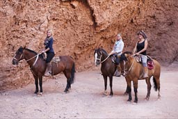 # young female tourists on horses in garganta de diablo, San Pedro Atacama.
