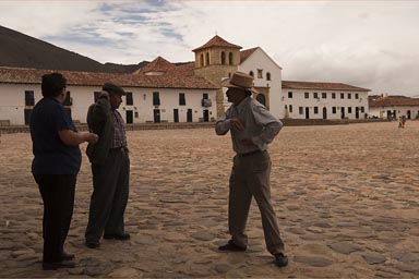 Men discuss and joke on plazza of Villa de Leyva.