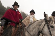 Men on horses and in ponchos gather in fog in Salinas, Ecuador.