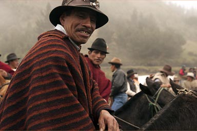 Riders in red and black striped ponchos, Salinas de Guaranda, Ecuador.