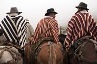 On horsebacks, in ponchos, Indigenas horses and bulls fiesta, Salinas de Guaranda, Ecuador.