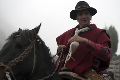 Red poncho and hat, white shal. Indigeno smiles. 