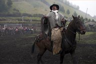 Man on horse, black and white poncho and llama wool. Salinas de Guaranda.