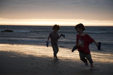 Boys in front of sining wet beach. Peru, mancora.