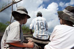 In a canoe, the boys behind Riber, on River Huallaga. Sun beats down on us.