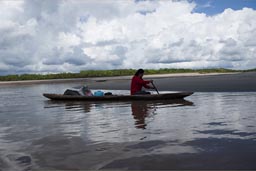 The lady paddles the canoe with the supplies.