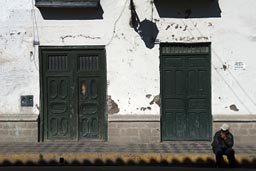 Cajamarca, morning, a man sits on side walk.