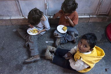 My boys and Huaracininio. Sit on pavement, late, enjoy a snack, Huaraz, Peru.