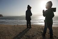 Yumaque beach, the boys against a sun, Paracas, Peru.