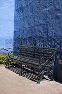 Blue wall, black iron bench, gardens in Santa Catalina convent, Arequipa.