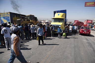 A truck has lost its precious load, Inka Cola bottles, all on the road, people rush to get their SUnday colas, Peru, Arequipa.