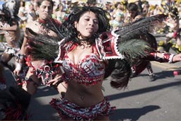 Dancer in red decorated bikini and feathers, extatic dance, Arequipa Day.