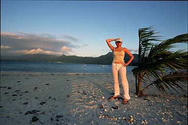 Agnieszka wearing at cap next to a palm tree catching the last sun of the day