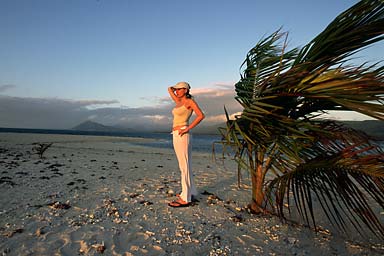 Agnieszka wearing at cap next to a palm tree catching the last sun of the day